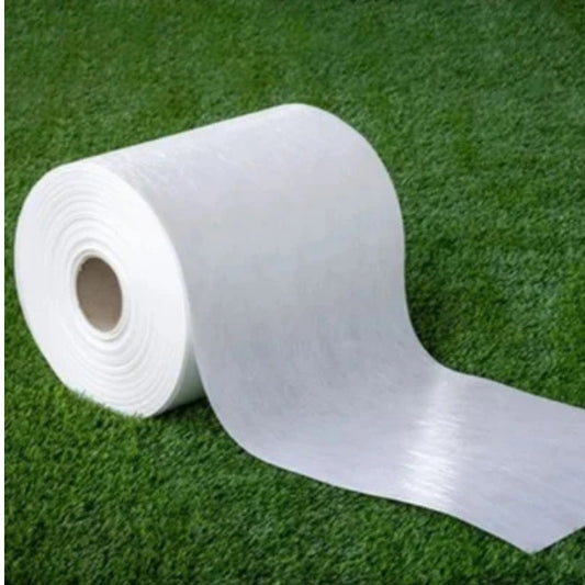 Roll of white material on a green grass background